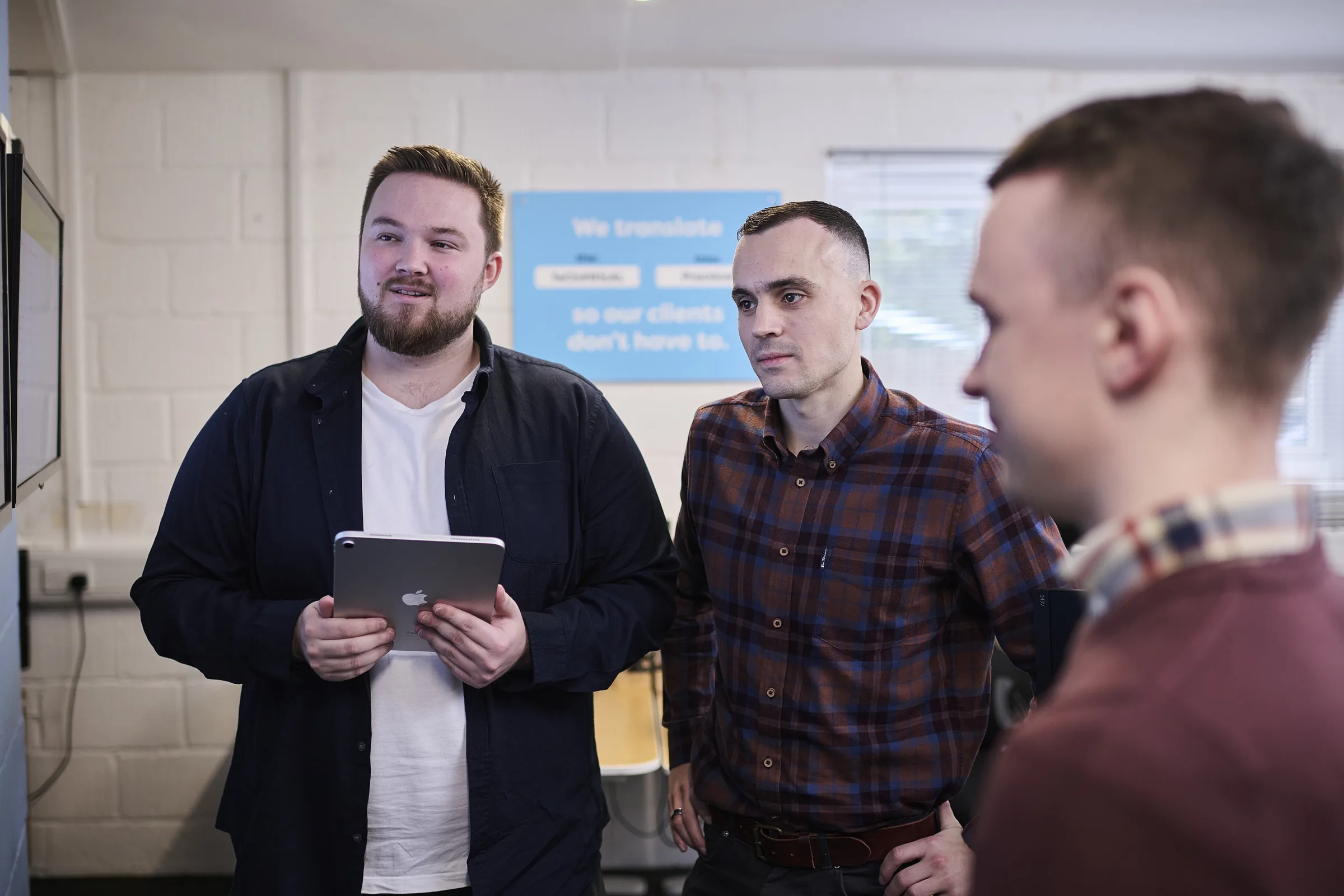 Senior Osiris consultant discussing an AI roadmap with a leadership team around a tablet.