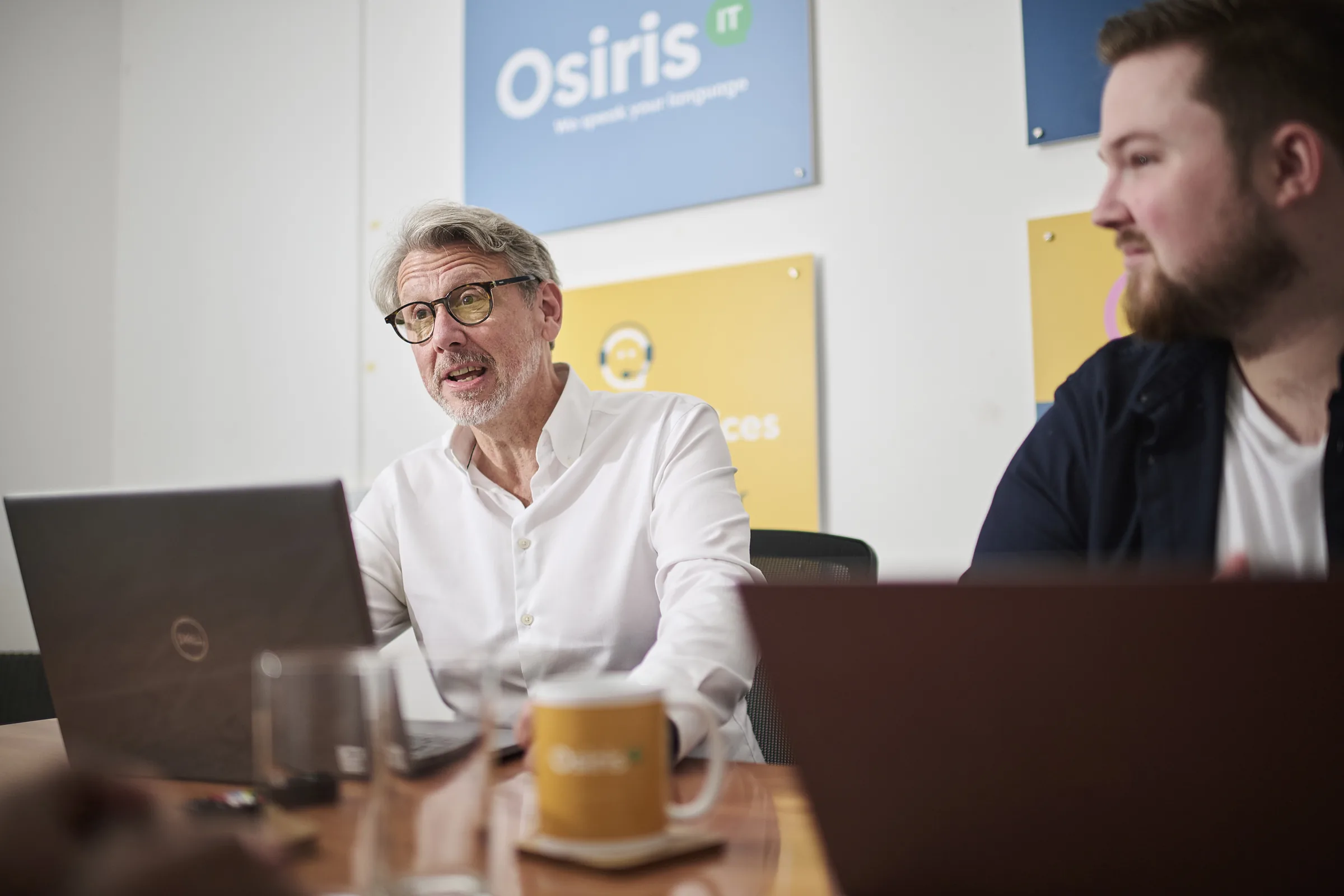 Senior Osiris consultant reviewing a commercial technology roadmap in a meeting room.