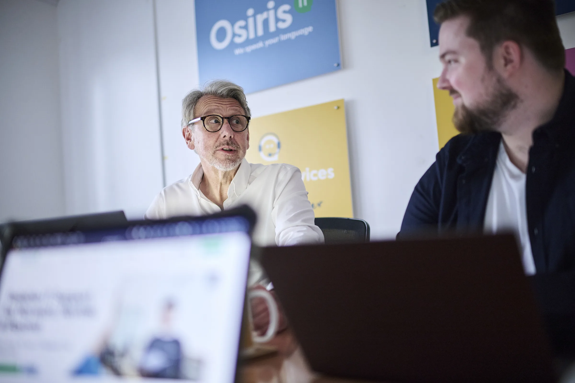 Senior Osiris consultant reviewing licensing and renewal priorities in a meeting room.